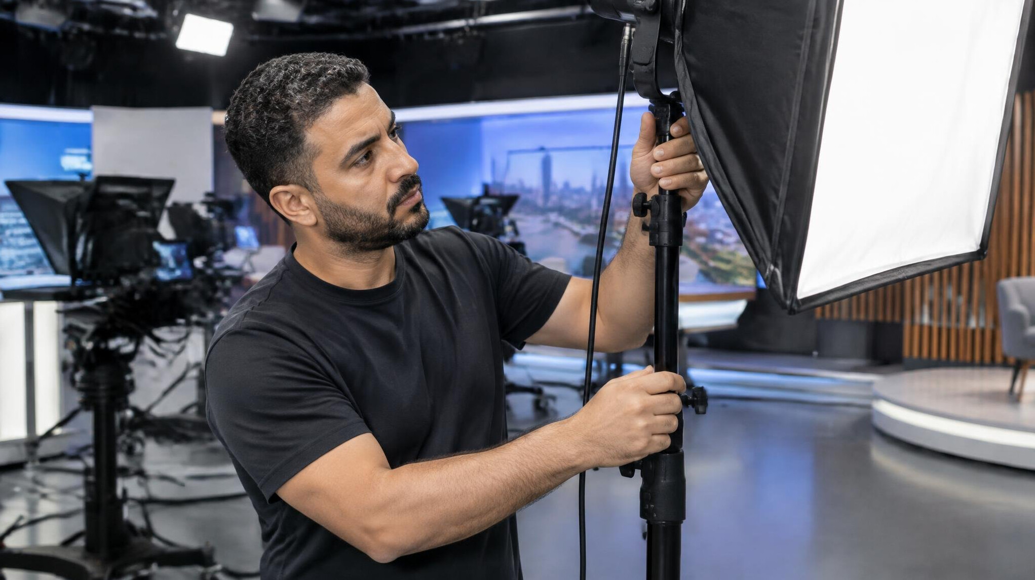 Belgian crew member adjusting a studio softbox light